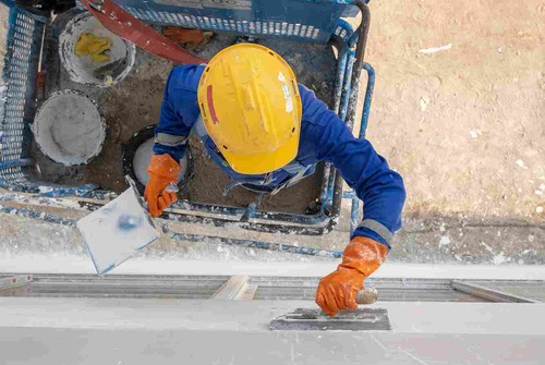 Worker Standing On Lift And Applying Plaster | UltraTech Cement