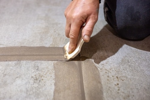 Applying tape to a floor joint using a tool | Ultratech