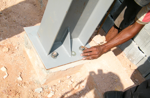 Steel column anchored to a concrete foundation with base plate, bolts.