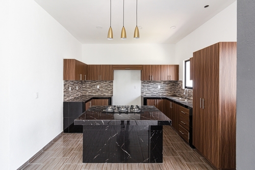 Wooden kitchen cabinets with a black marble island | Ultratech