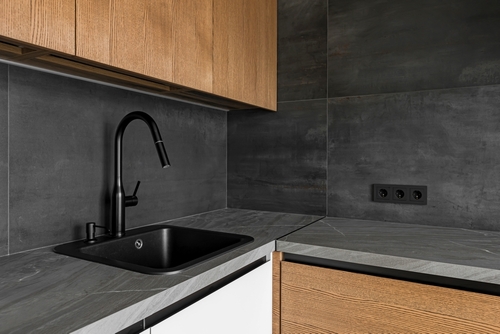 Black kitchen sink with a black tap and wooden cabinets | Ultratech