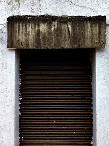 Closed Metal Shutter with Weathered Lintel