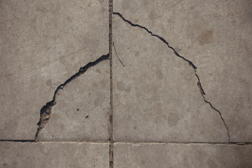  A large curved crack spreading across concrete tiles | Ultratech