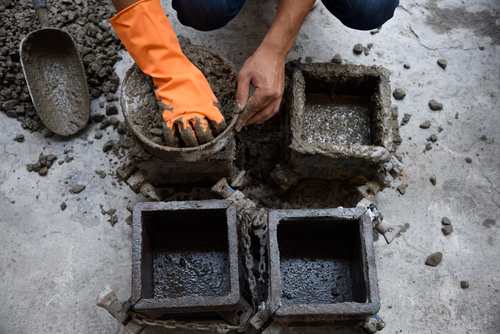 Concrete ke sample ki jaanch karte hue mazdoor