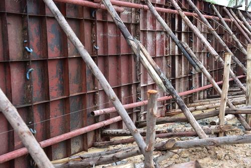 Construction site par diwar ki dhalai ke liye lagi lohe ki shuttering plates 