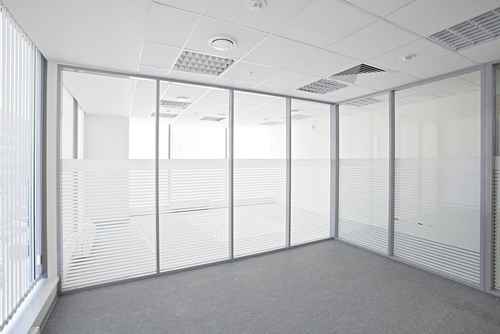 Kanch ke partitions aur frosted glass wala khali office cabin