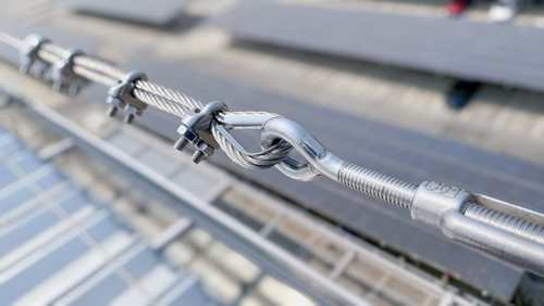 Safety aur support ke liye heavy steel cable par lage metal clamps aur tightener