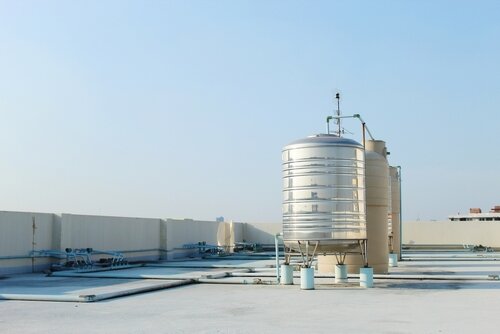 A large stainless steel water tank is mounted on top of the building. To reserve water when the water supply does not flow