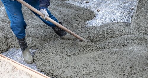 Workers level out the concrete mix at a construction site. Technologies