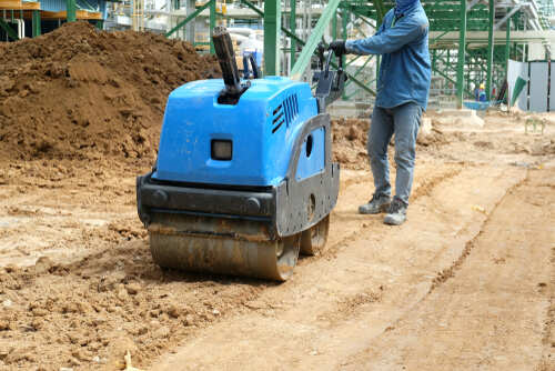 Worker are controlling mini vibratory road roller compactor machine or walk behind baby road roller, walk behind road roller compactor in the construction project area