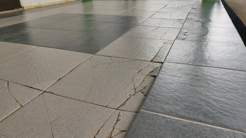 cracked ceramics in building corridors caused by weather and heavy loads