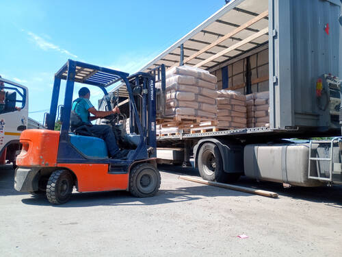 Krasnodar, Russia - June 13, 2019: Unloading bags of cement from a truck with a forklift.