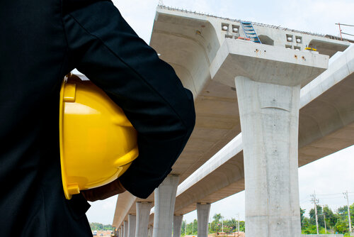 Engineer with bridge under construction background