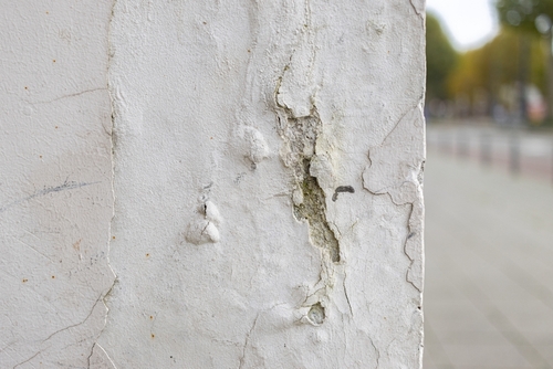 Bubbled paint on a wall. Paint damaged by water. Poorly isolated wall with bubbling paint.